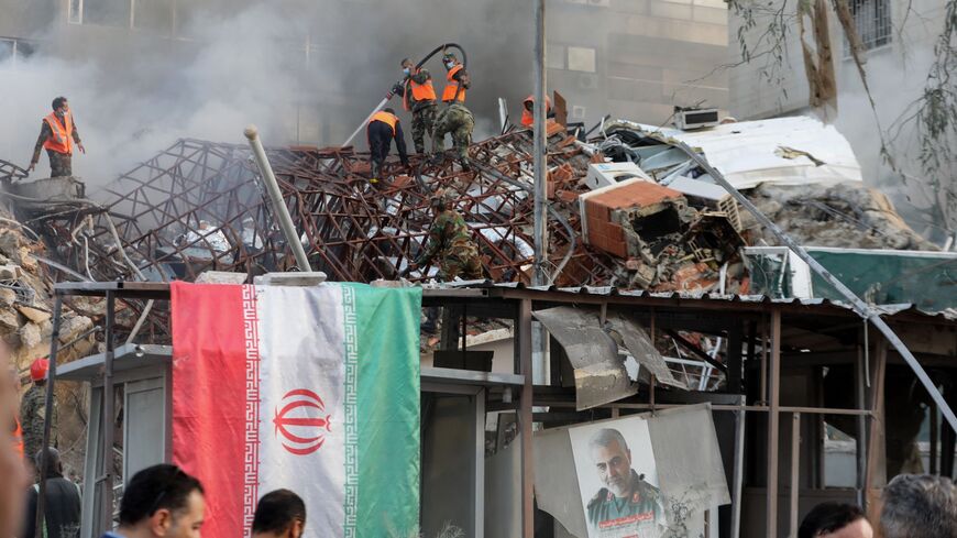 Emergency and security personnel extinguish a fire at the site of strikes which hit a building annexed to the Iranian embassy in Syria's capital Damascus on April 1, 2024.